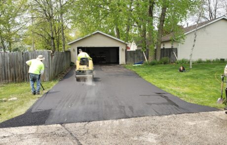 a photo of Asphalting Services Kenosha, contractors working on a residential driveway.