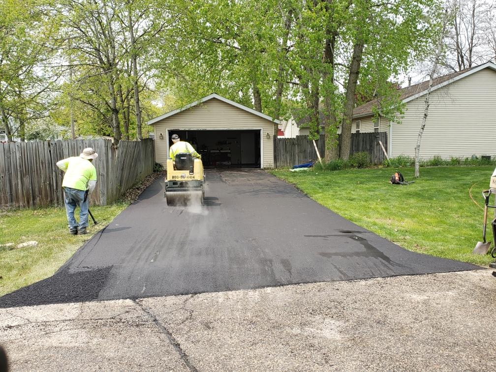 a photo of Asphalting Services Kenosha, contractors working on a residential driveway.